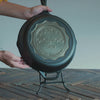 Personalized congratulations skillet being placed on display stand.