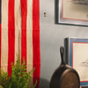 Personalized skillet being hung on wall near an American flag.