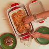 Freshly baked cinnamon rolls being served out of casserole dish.