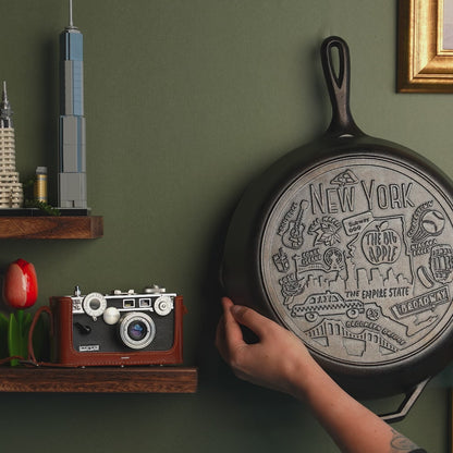 Close up view of the engraved design on bottom of skillet, while skillet is displayed on wall.
