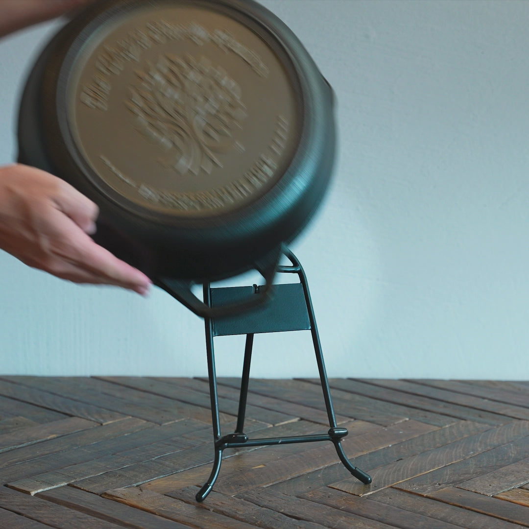 Someone placing personalized family reunion skillet on display stand.