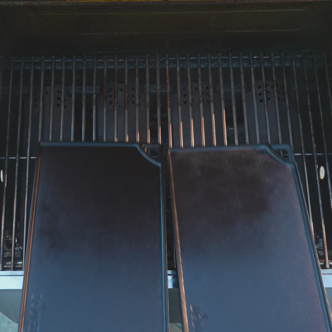 Smash burgers being made on 2 griddles using the grill press.