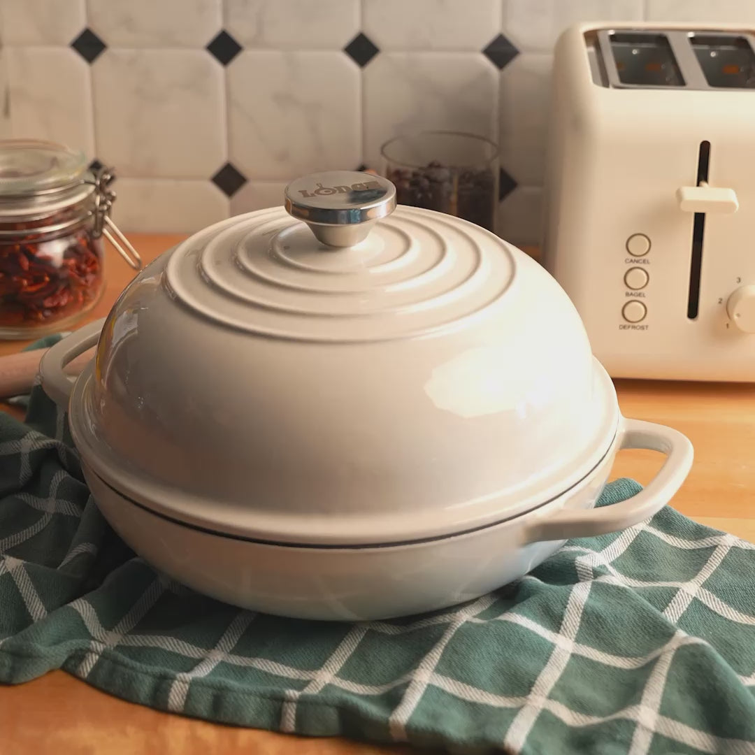 Someone lifting lid off of bread oven, revealing steam and a beautifully baked bread.