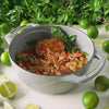 Someone lifting lid on dutch oven revealing a freshly made dish.