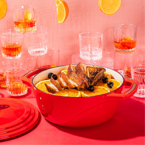 Freshly prepared old fashioned infused pork belly in front of glassed of Old Fashion's and oranges.
